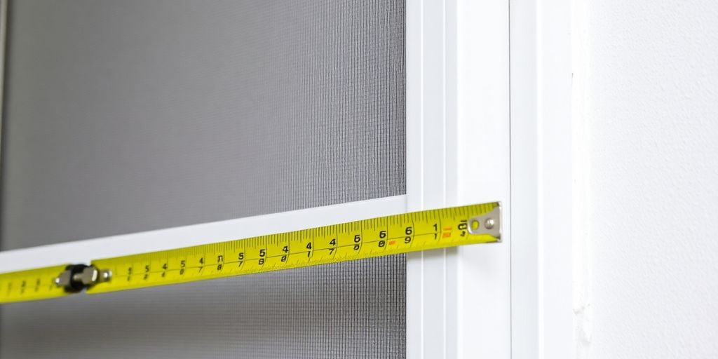 Measuring tape on a window screen frame.