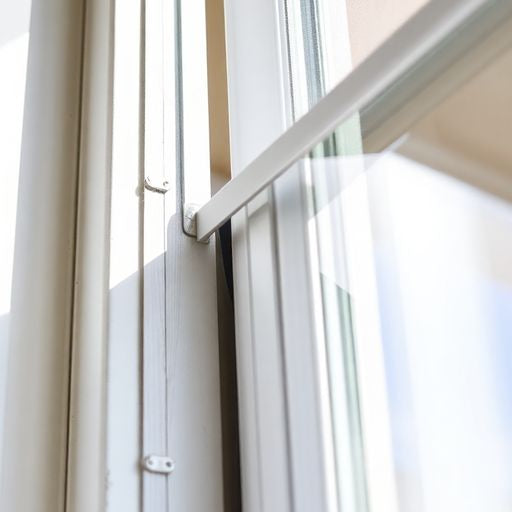 Sealing a sliding glass door frame with weather stripping.