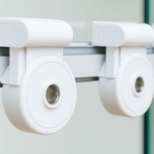 Close-up of sliding glass door wheels and track.